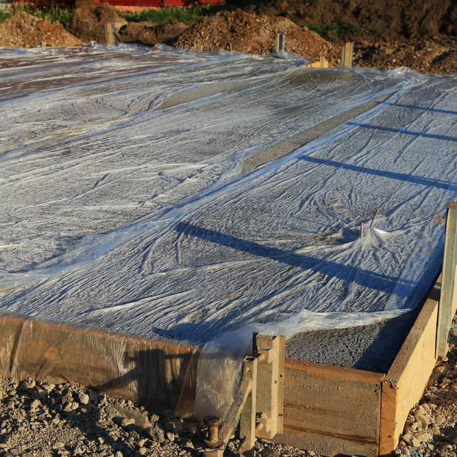 Base plate freshly concreted. To keep the fresh concrete moist, it is covered with foil. Sunlight. Newly built with formwork.