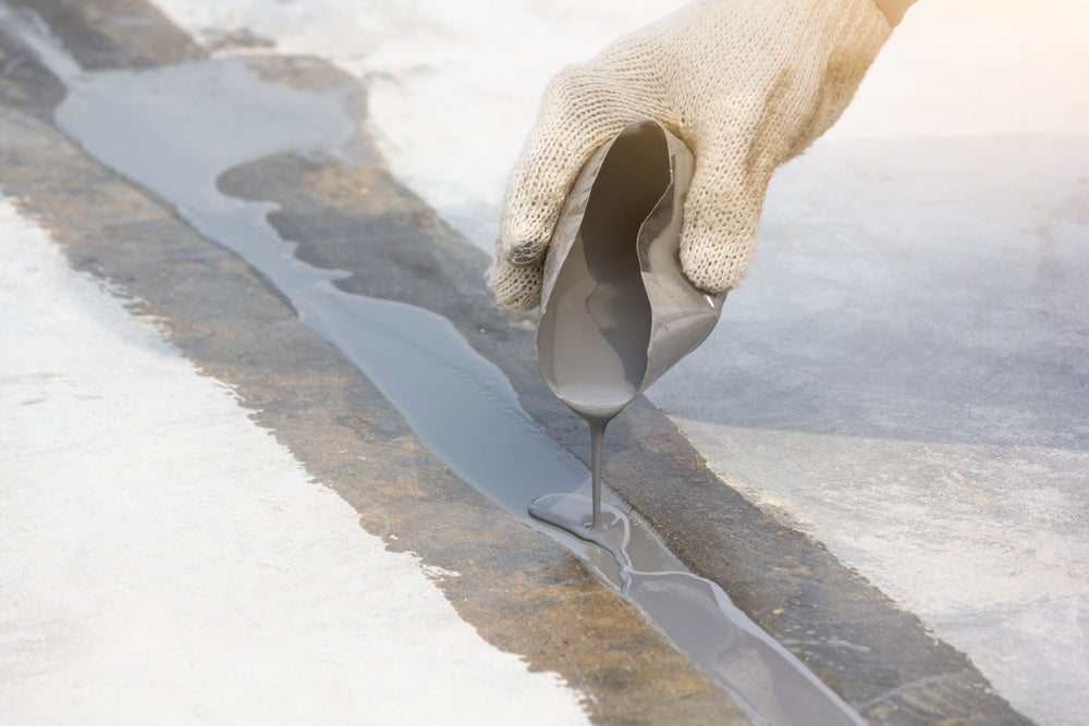 man pouring filler into expansion joint