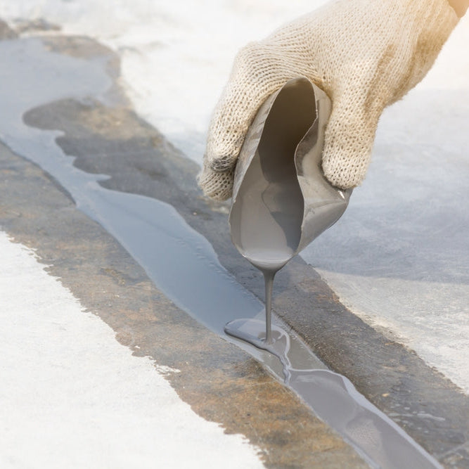 man pouring filler into expansion joint