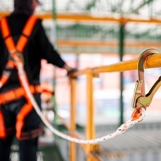 Construction worker practicing scaffolding safety wearing a harness.