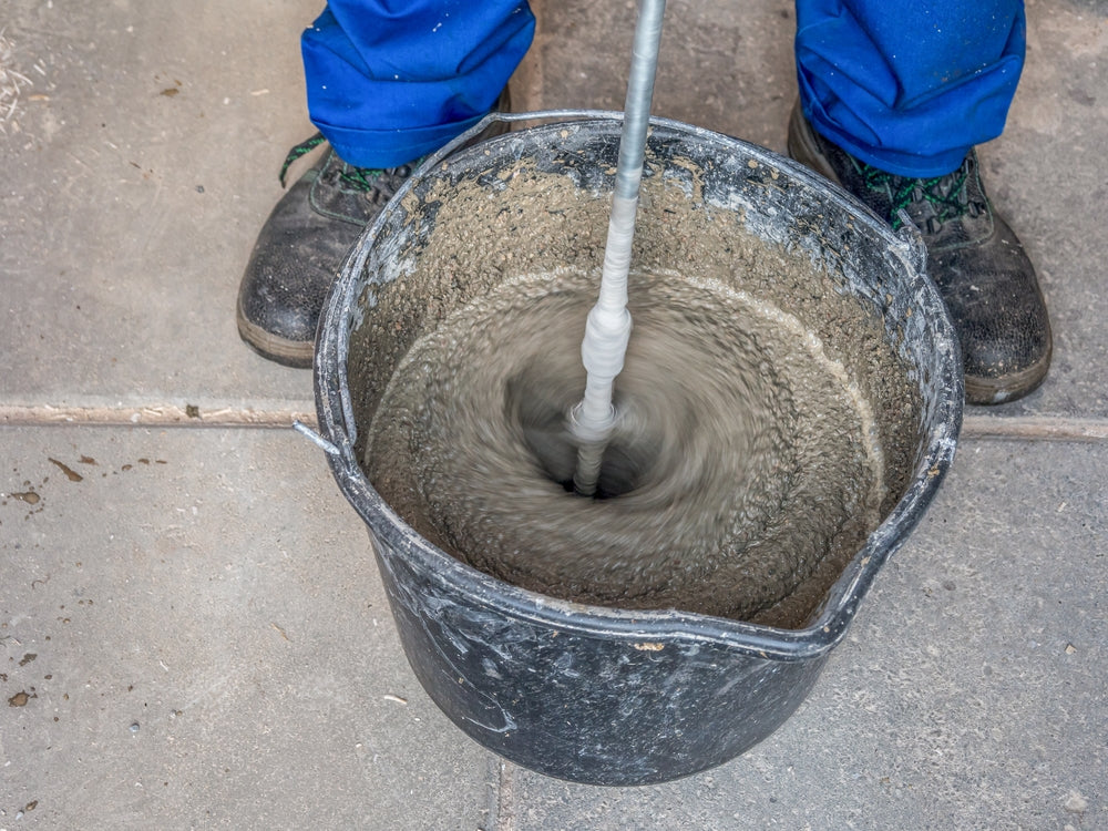 construction worker mixing a type of mortar in a bucket