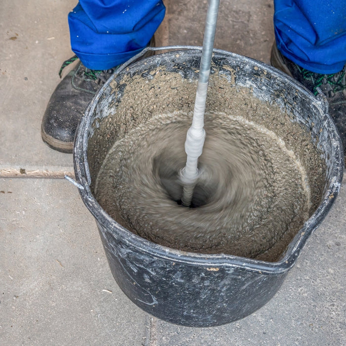 construction worker mixing a type of mortar in a bucket