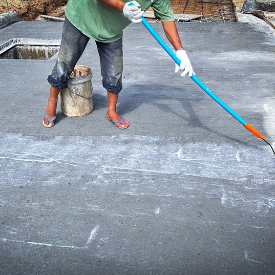 Technician applies concrete curing agent to prevent cracking. concrete primer Steps for applying foundation with a roller on concrete floors Primer for strengthening the surface.