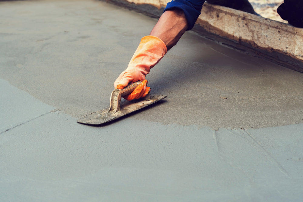 image of a man troweling concrete to achieve a smooth finish